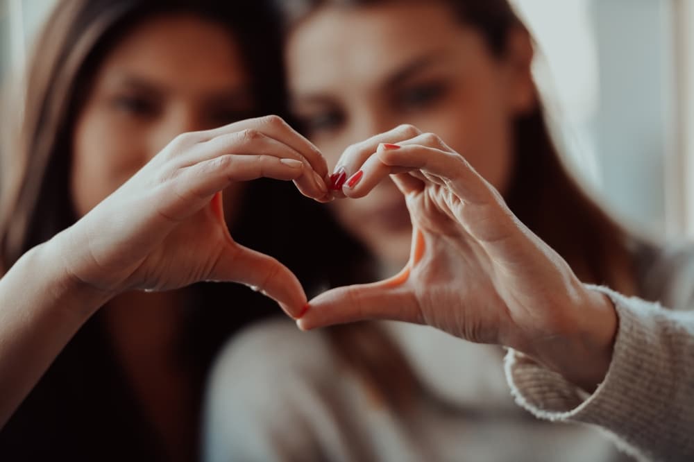 same sex female couple making hearts with their hands during their romantic Midwest getaways
