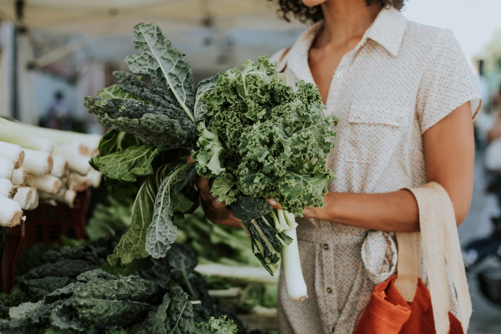 A woman with kale and other produce from the Missoula Farmers Market