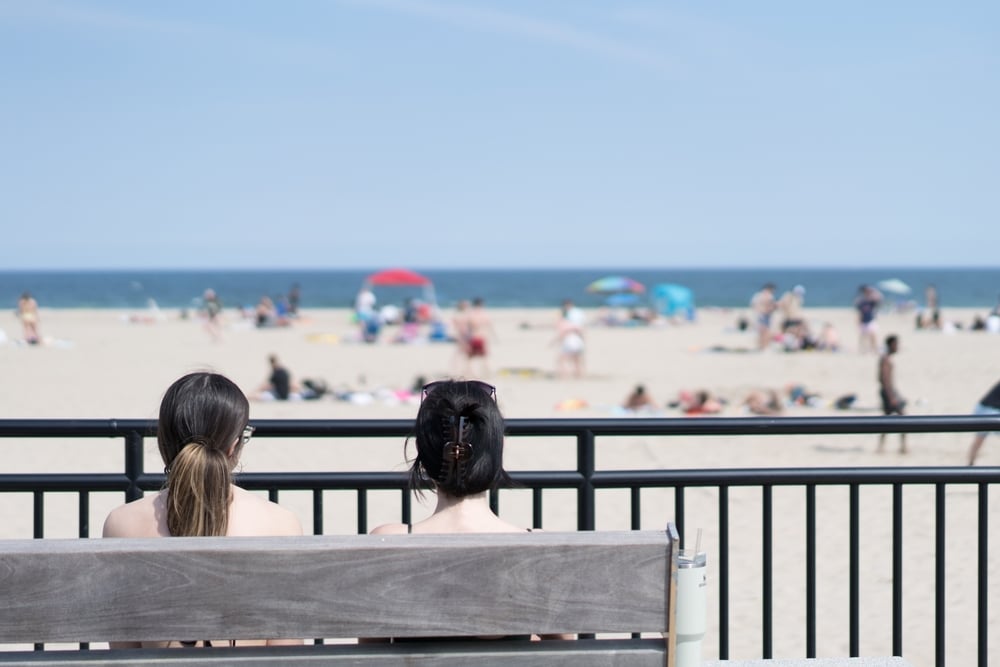 Two women sitting on a bench overlooking Hampton Beach on the New Hampshire Seacoast