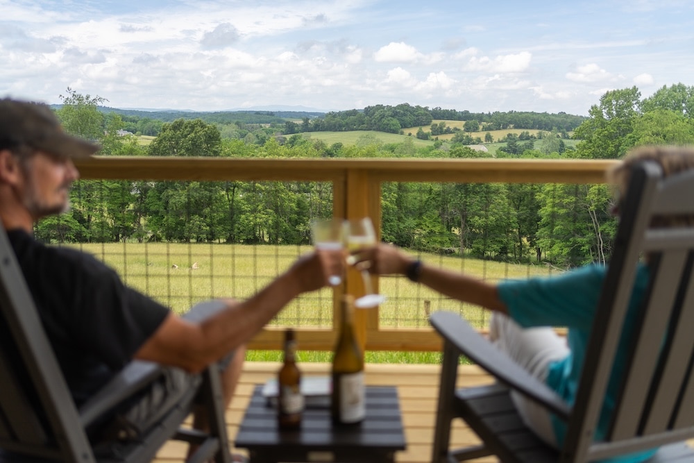 Two people on the porch relaxing at one of our luxury cabins in Virginia