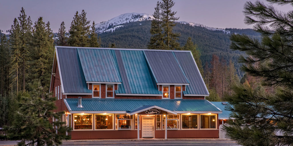 Exterior of St. Bernard Lodge with Snow Covered Carter Mountain in backgroundin Ba