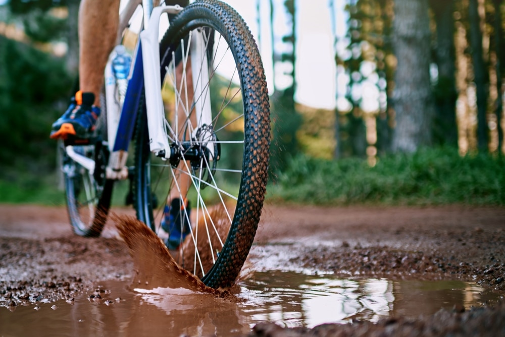 mountain biker going through the mud on trails like those at the Waterville Valley Ski REsort