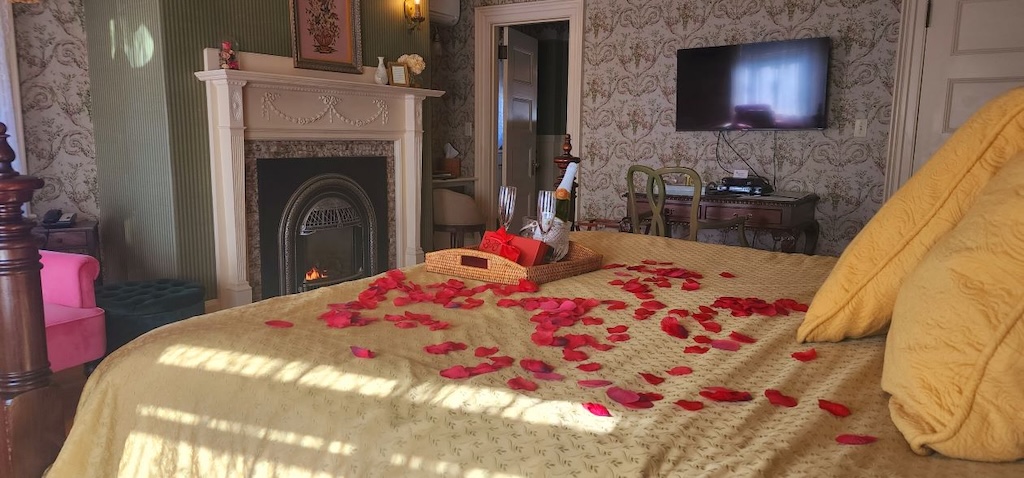Maine in the fall with bedroom and bed with rose petals and a bottle of sparkling cider