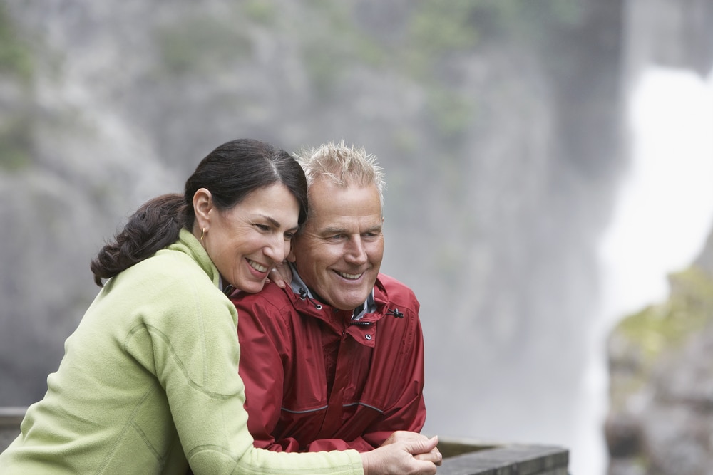 Swallow Falls State Park, happy middle-aged couple hiking to a waterfall outlook in Maryland