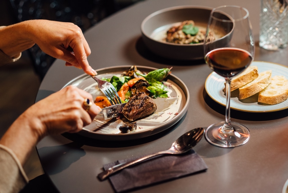 Enjoy the best places to eat in Missoula. Close up of a person cutting a steak.