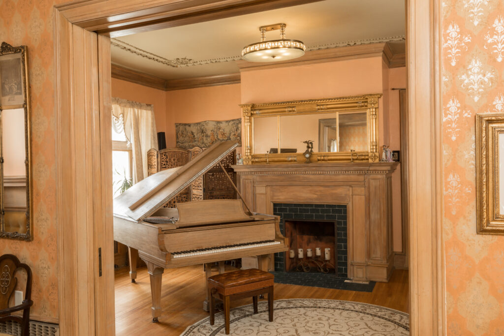 Piano and fireplace in common room at Ringling House, our Bed and Breakfast in Wisconsin.