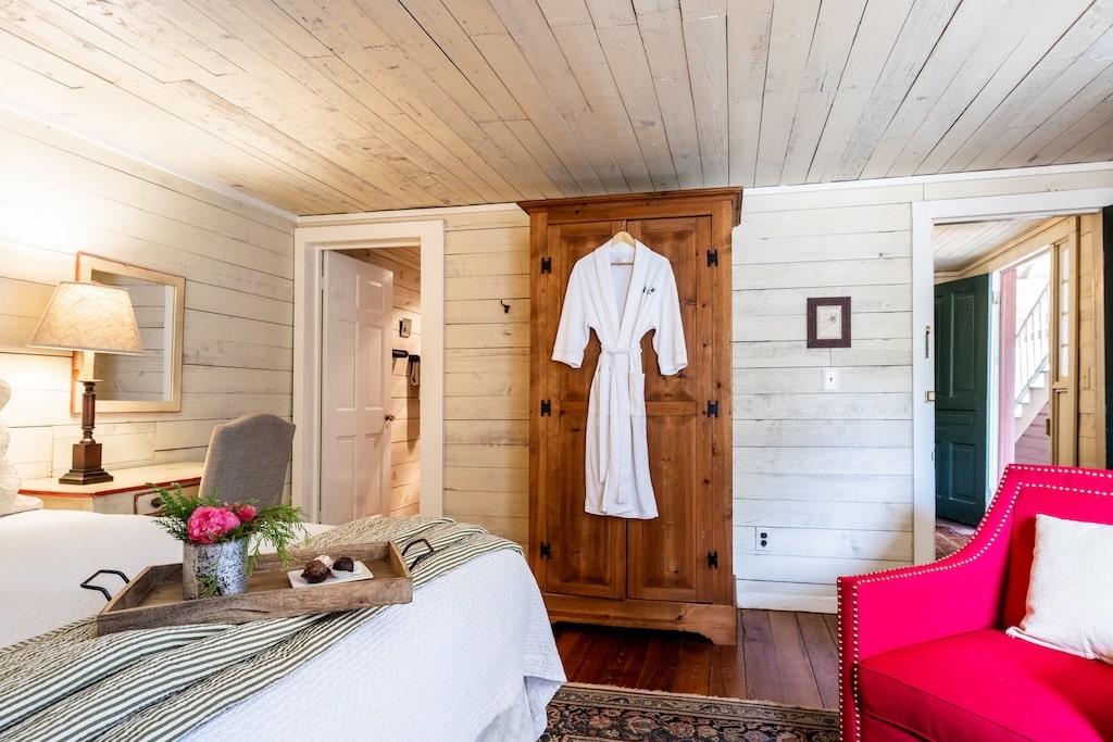 Stay at our North Georgia Bed and Breakfast, in one of our King Rooms. Image of bed and bathrobe, also highlighting natural wood finishes.