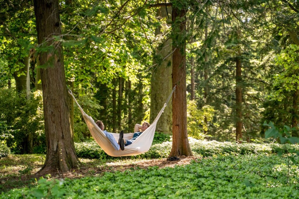 A couple laying in a hammock on The South Mountain Inn. Our grounds are a lovely place to relax after visiting loved ones at Caron Rehab PA.