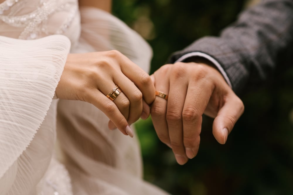 Visit the best romantic getaways in NC at The Orchard Inn and Spa in Saluda. Here is a close up of two hands with wedding rings on.
