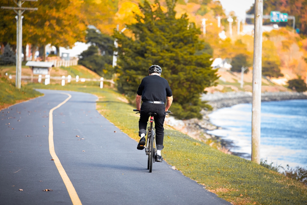 A man riding down a bike trail on Cape Cod in October