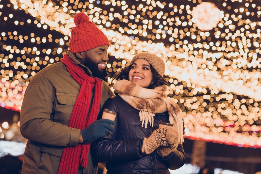 Couple bundled up, holding hot cocoa at Bentleyville Tour of Lights.