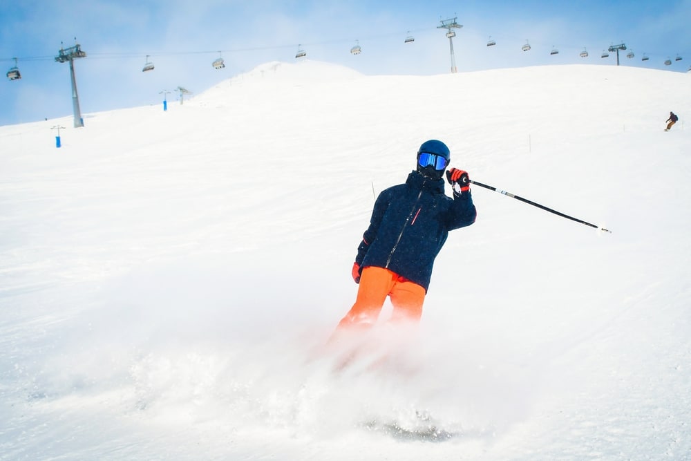 Have fun with Missoula skiing at the Missoula Snowbowl this season! Skier with chairlift in the background.