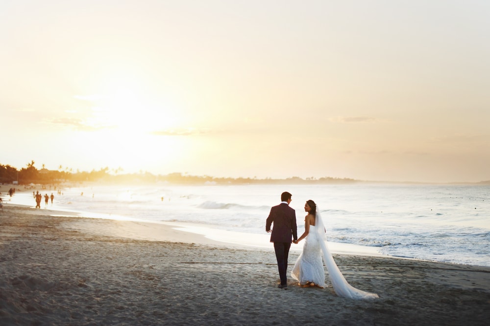 Choose from various St. Augustine elopement wedding packages. Newlyweds walking down the beach after getting married at our St. Augustine Bed and Breakfast. 