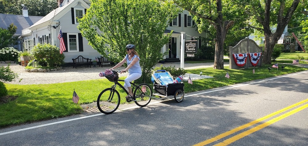 Woman riding down a bike trail on Cape Cod in October