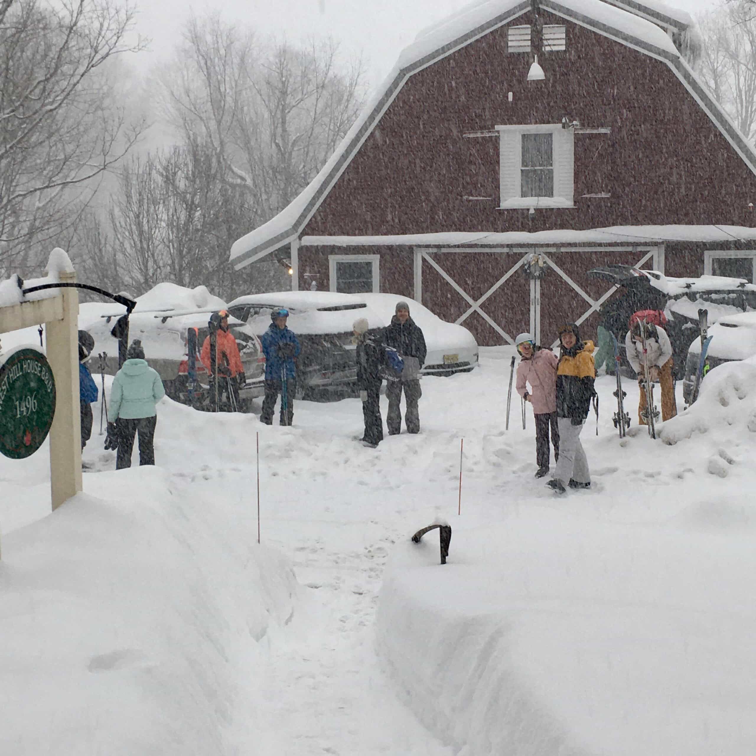 Skiers wait for a bus in the snow storm