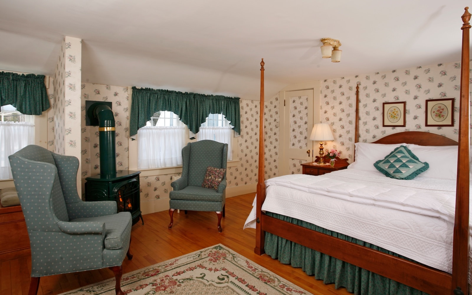 Stay at the best Bed and Breakfast in New Hampshire and enjoy a spacious guest room like this with a four poster bed and seating area. 