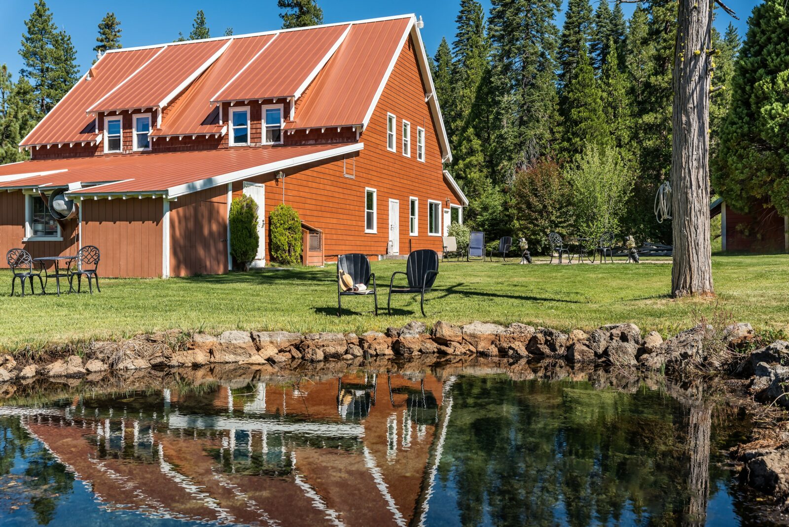 The exterior of St Bernard Lodge, seating by pond.