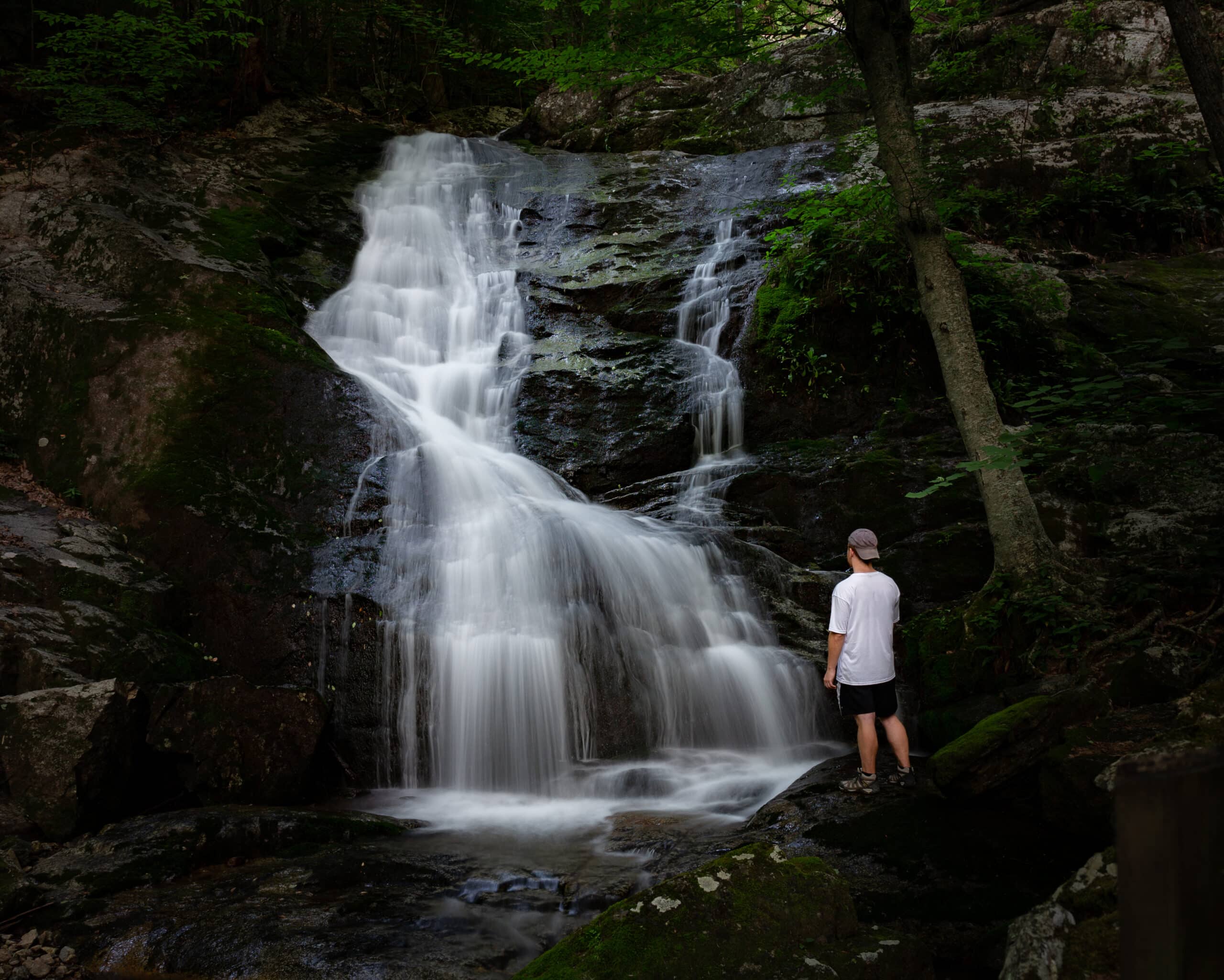 Man standing near Crabtree Falls, one of the best waterfalls in Virginia.