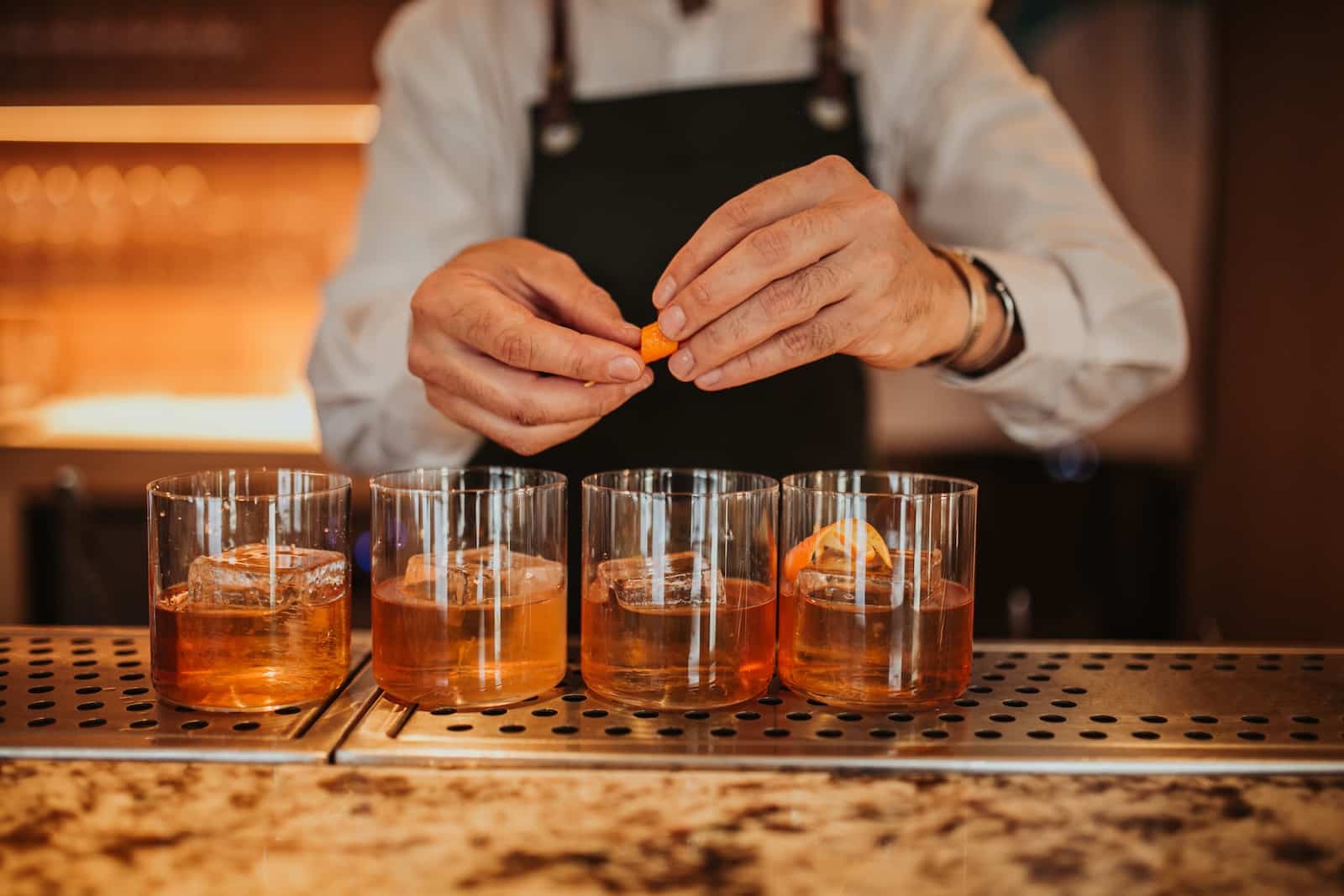 Enjoy an old-fashioned cocktail, a supper club staple, at any of the Wisconsin supper clubs. This bartender is preparing four drinks for his patrons. 