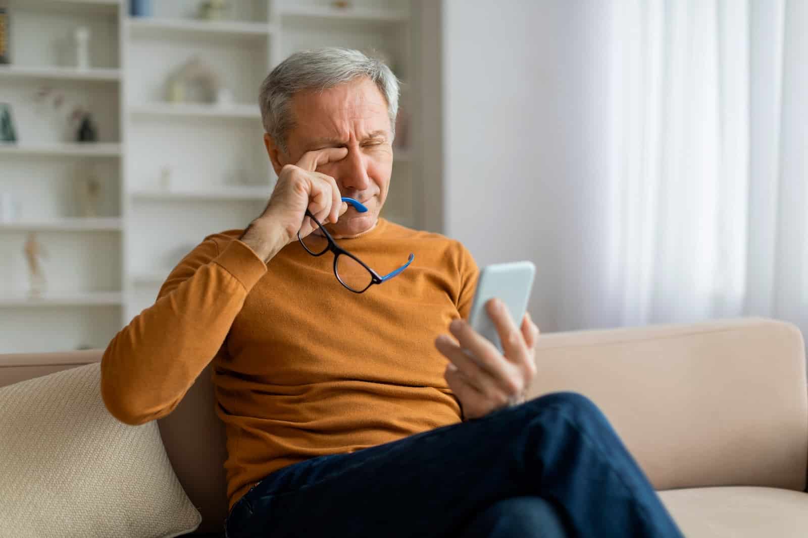 Man rubbing tired and dry eyes and possibly struggling with autoimmune eye disease