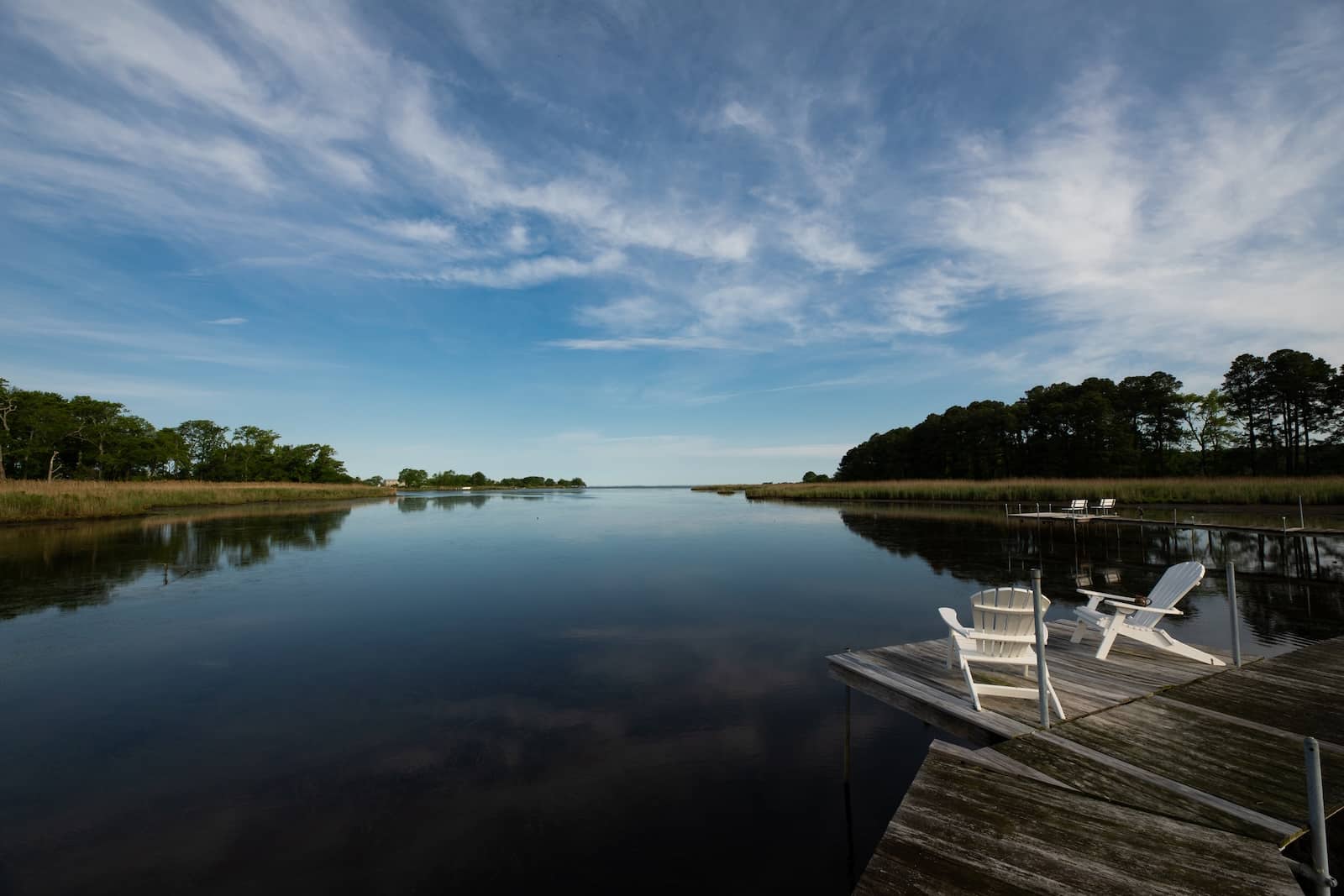 Two Adirondack chairs on the bay at our Bed and Breakfast in Rock Hall, Maryland.