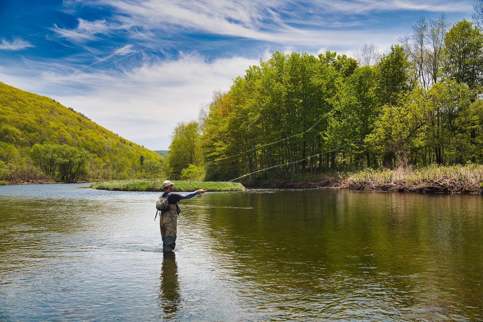 A day spent fly fishing is one of the exciting things to do in Missoula, Montana for outdoorsmen. Here is aman fly fishing in a river.