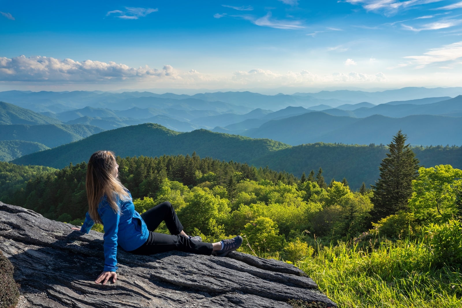 A woman relaxes on the top of a mountain after hiking near Asheville, NC.