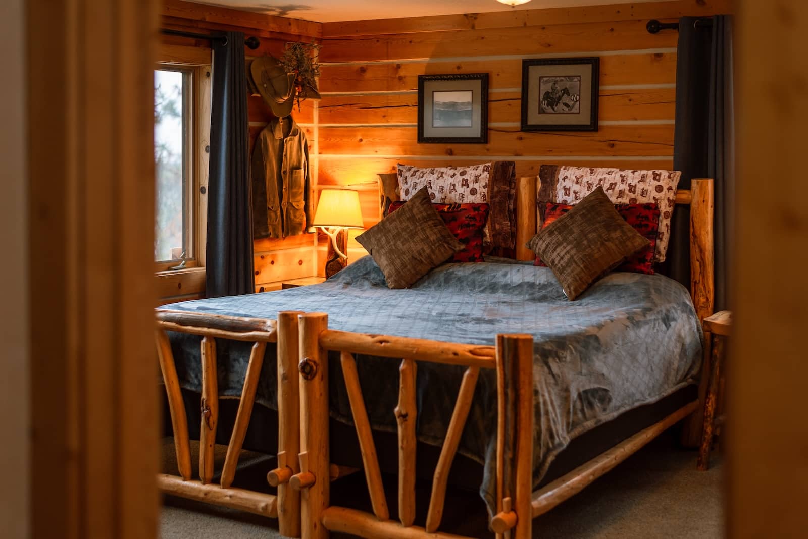 At our Montana Bed and Breakfast, you'll have access to premium guest suites with a queen-size bed, a blue comforter, and pillows in a log cabin style room.
