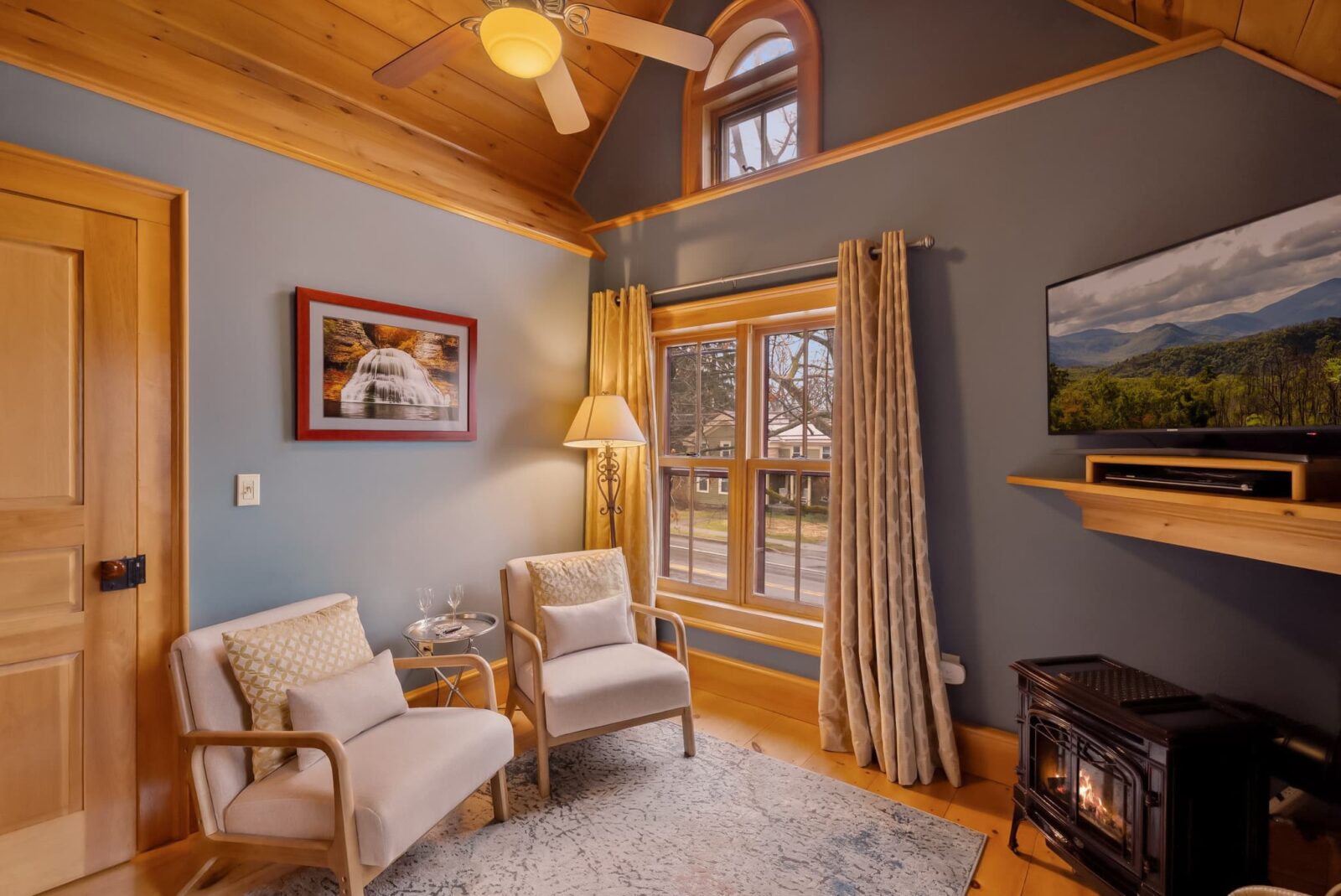 The Cayuga Suite at our Finger Lakes Wine Country Hotel with a seating area and wood stove.