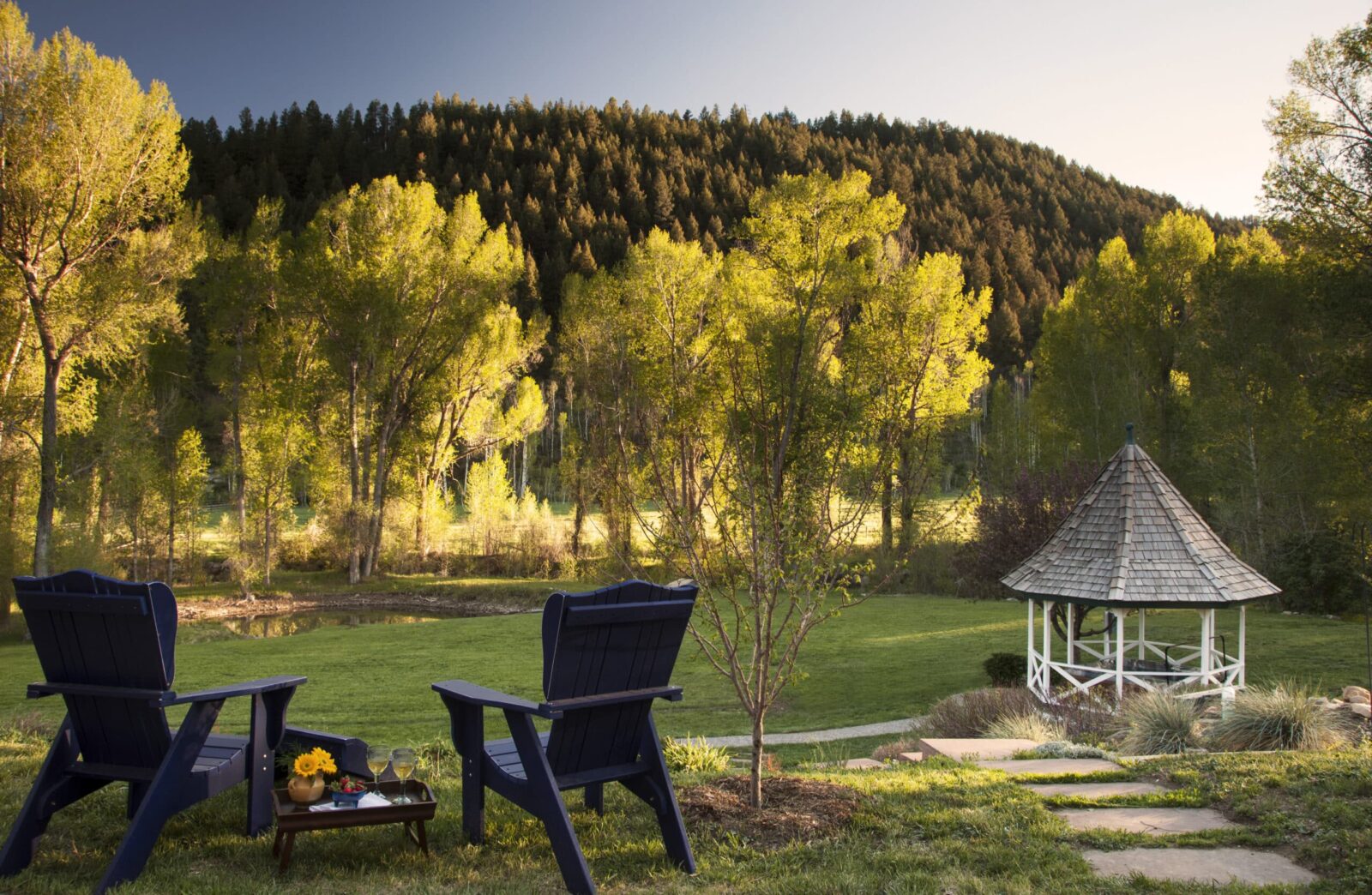 two outdoor chairs, a gazebo, mountains in the background. The beautiful grounds of our Bed and Breakfast in Durango.