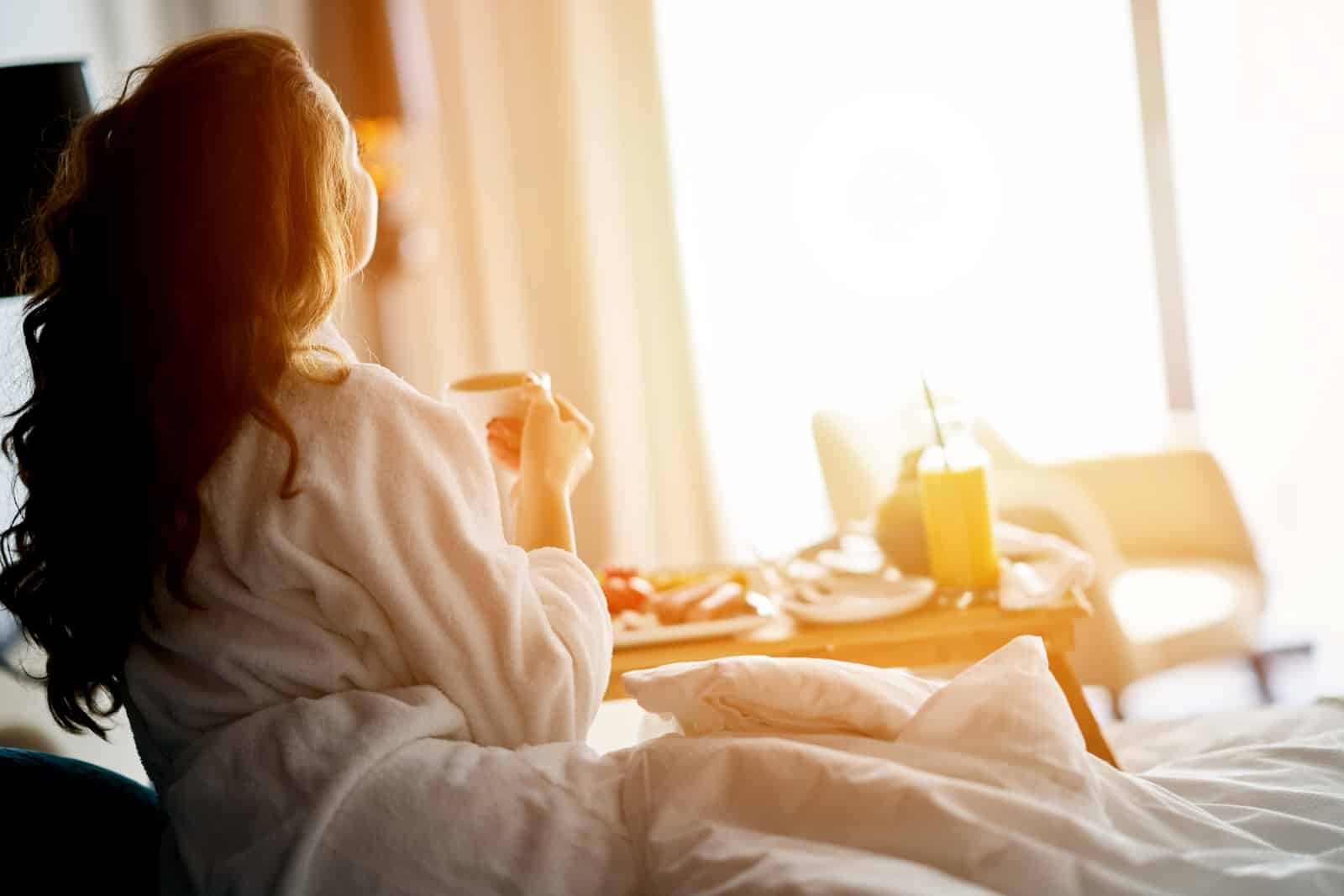 Woman enjoing Breakfast in bed, one of the best ways to relax in the morning before heading out on a bike ride on one of the best Rail Trails in the midwest