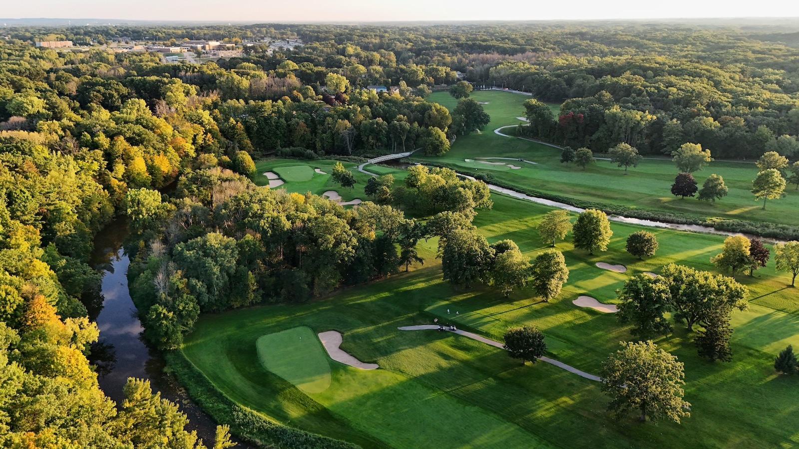 Blackwolf Run Golf Course is a panoramic view of rolling greens, trees, and a river.