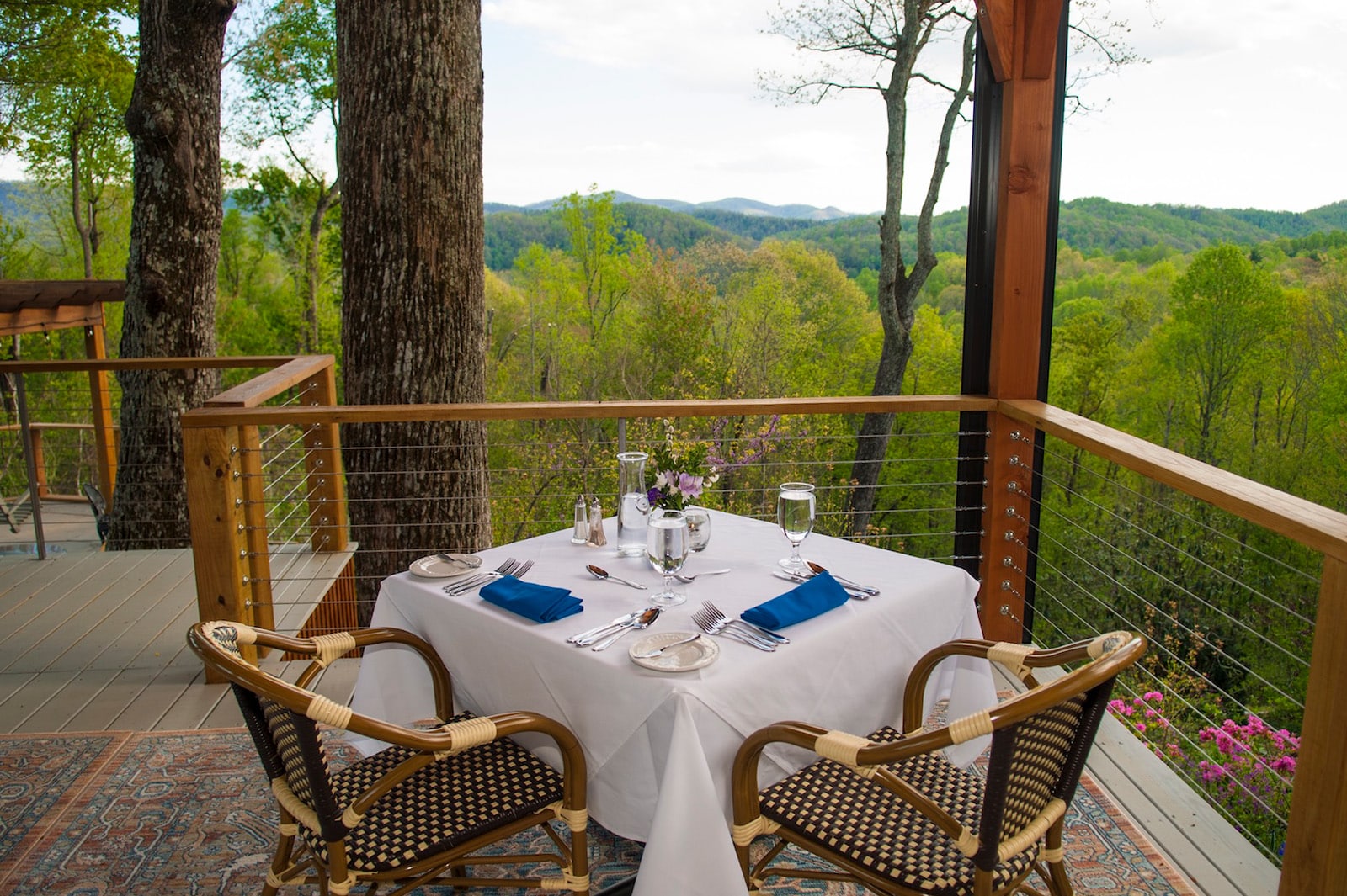 Dinner for two, featuring a table with a white tablecloth, place settings, and two chairs, overlooking the mountains at the best bed and breakfast NC mountains.