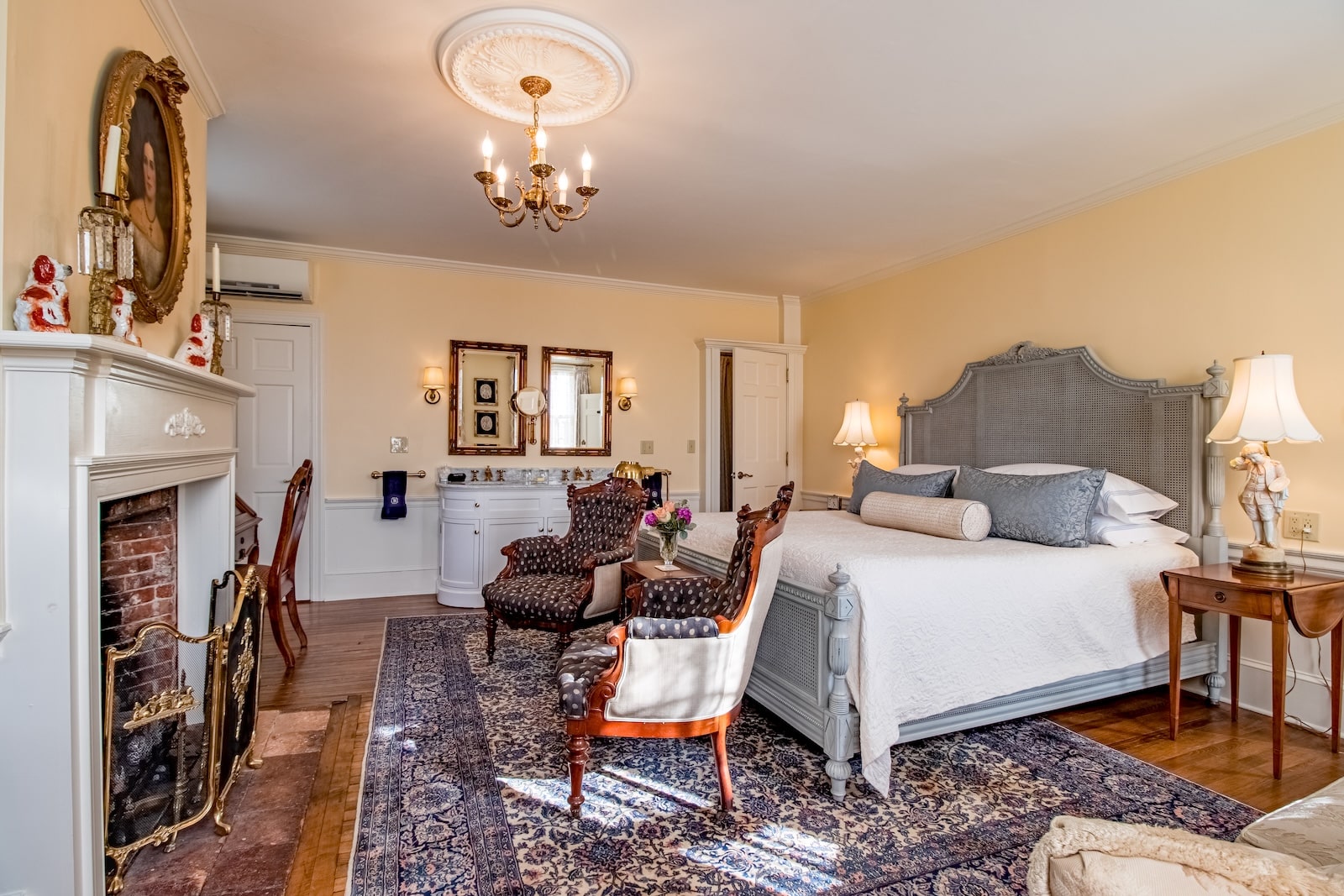 A guest room featuring a fireplace, sitting area, and cozy bed at one of the best hotels in Exeter New Hampshire.