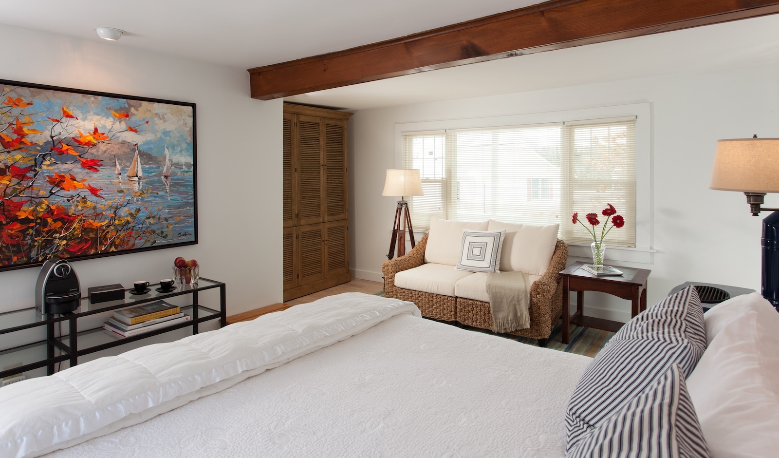 A guest room featuring colorful artwork, a king size bed, and a seating area at a New Hampshire Bed and Breakfast.