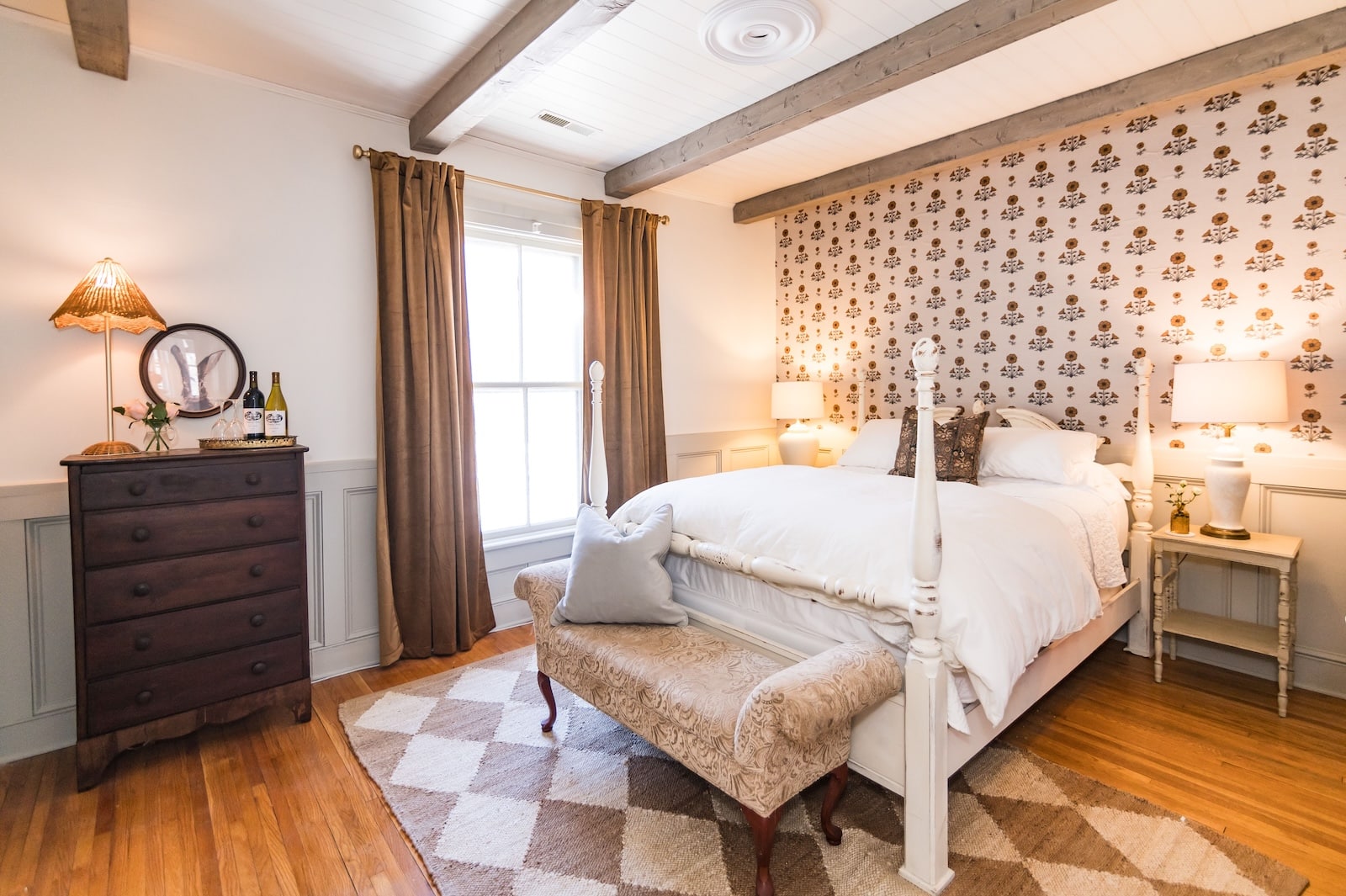 A cozy guest room, featuring a be, dresser, rug, and wallpaper, what you'll find at the best Bed and Breakfast Charlottesville VA.