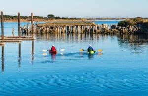 A couple kayaking in Bandon's Coquille River, one of the best Bandon boat tours.