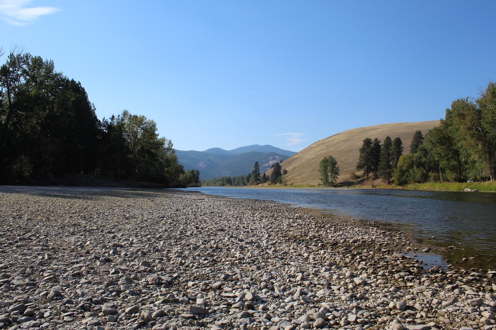 The Bitterroot River with mountains in the background in Montana, the setting for the Travelers Rest State Park.