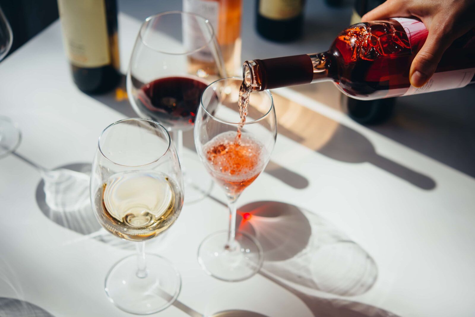 Three different wine glass with red, white, and rose wine being poured at Fletcher Bay Winery.