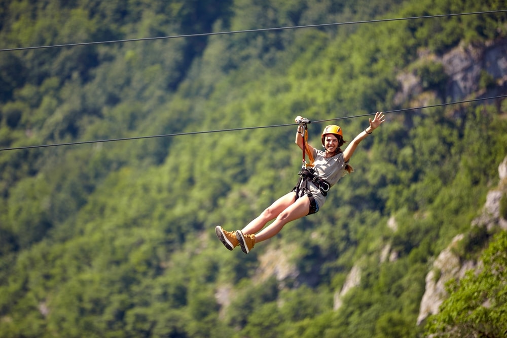 Woman riding the Gorge zipline in the mountains.