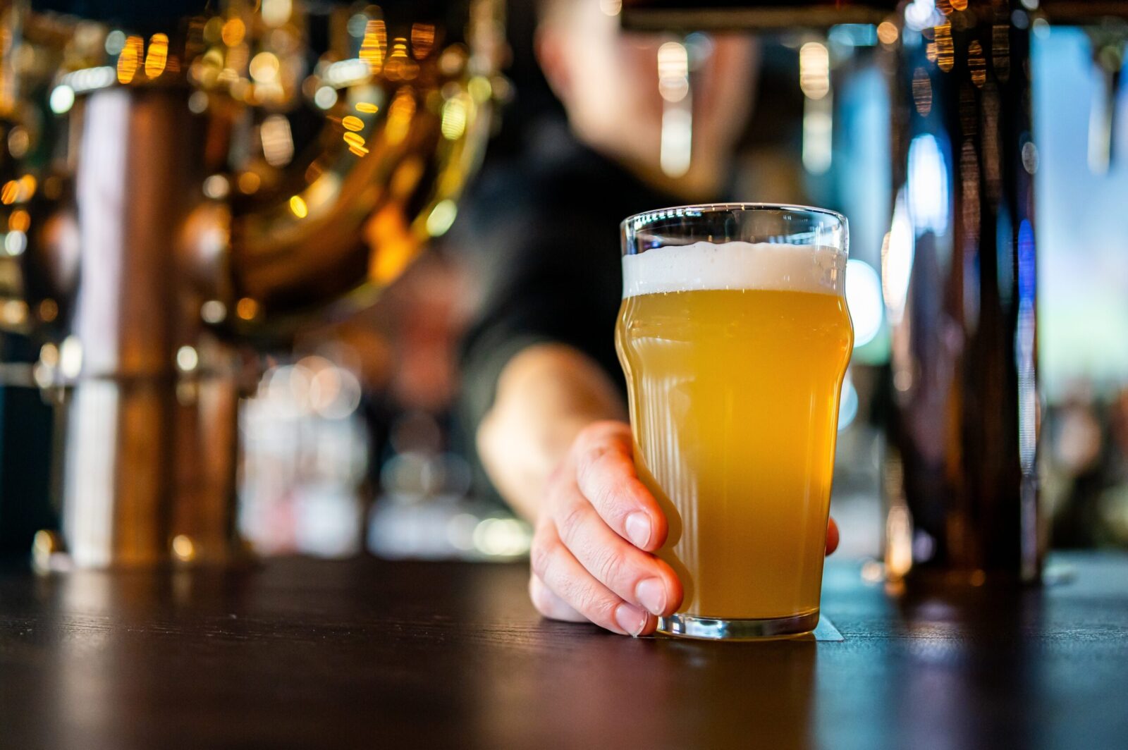 Bartending passing beer across bar at Hood River breweries