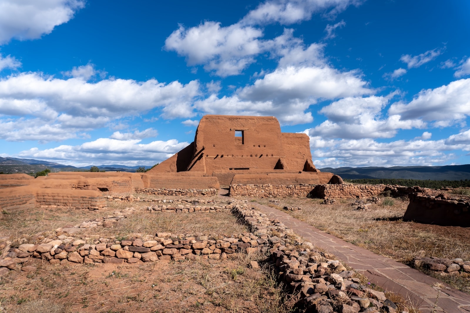 Ruins featuring an old structure and rocks with clouds and open skies at the Pecos National Historical Park in New Mexico.