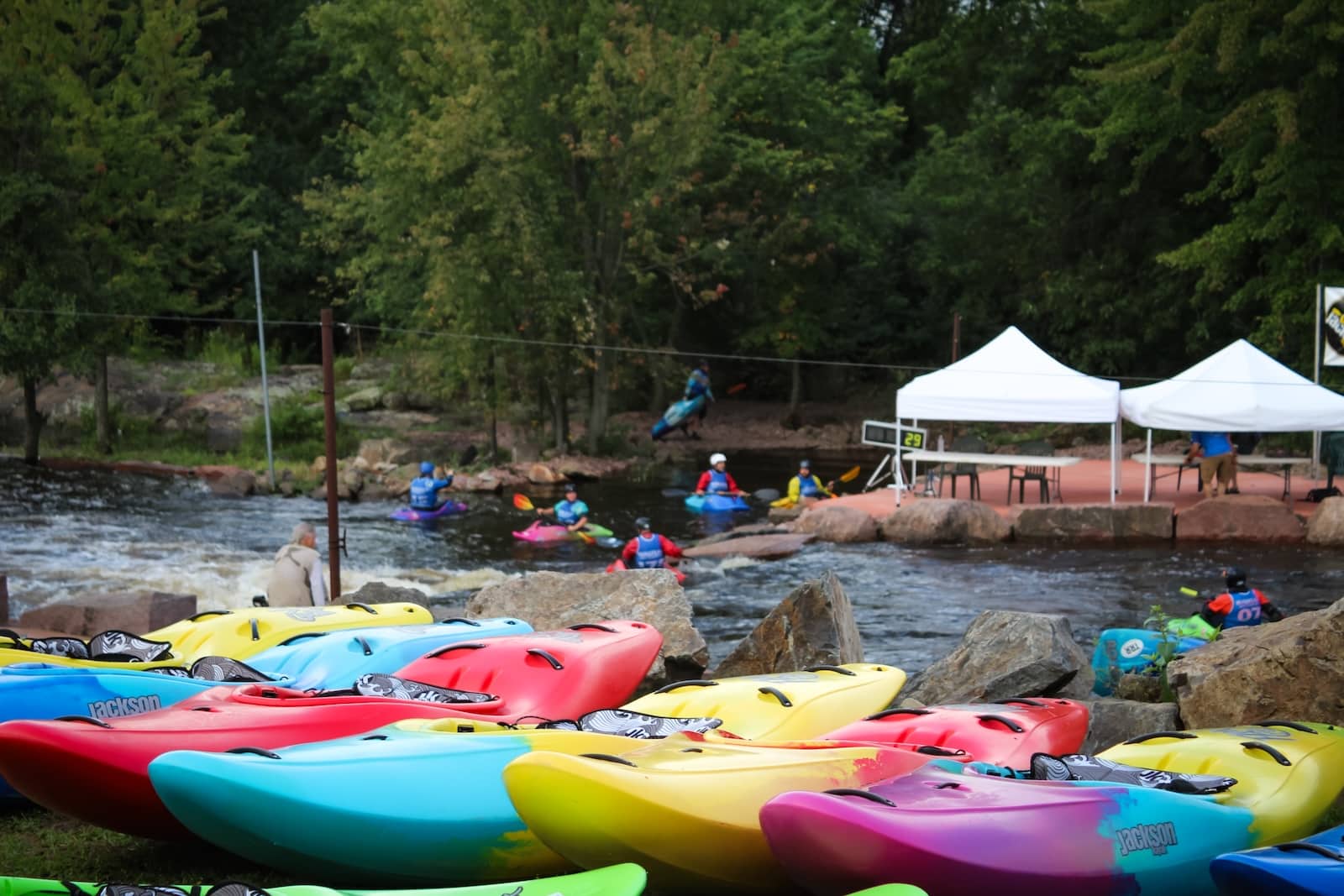 Colorful kayaks lined up on the river at the Wausau Whitewater Park.