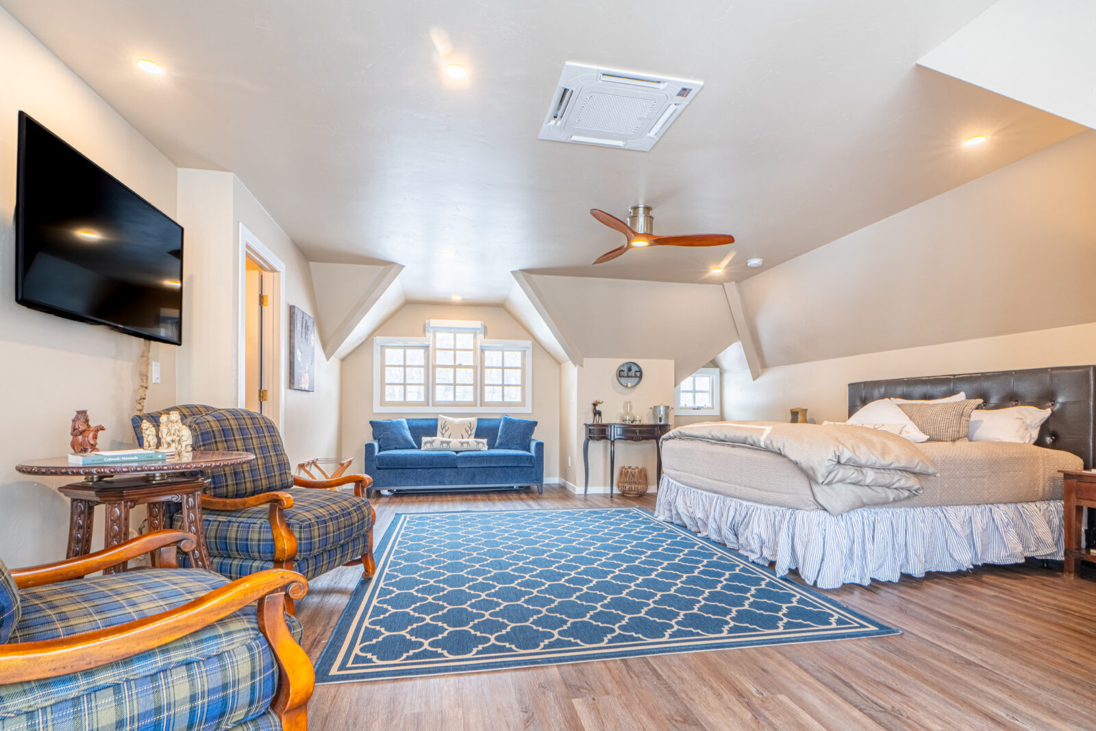 Wildcat Creek Guest Room with blue seating, king bed, and gabled windows