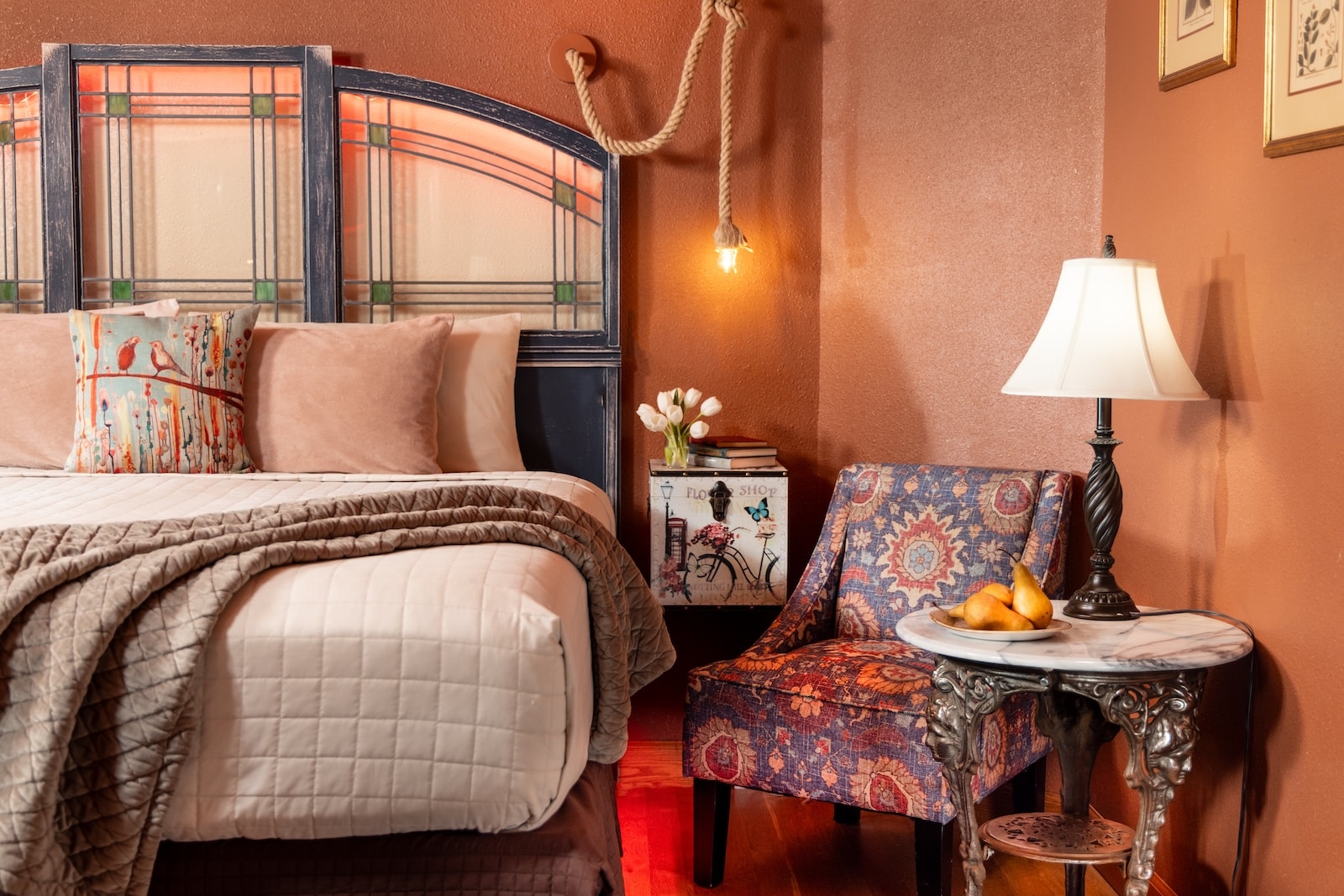 A bed with a chair, night stand, and lamp, part of a luxury guest room at the best Bed and Breakfast Wisconsin has to offer.