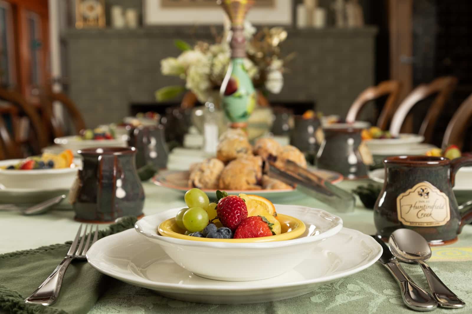 A bowl of fruit at a tablescape with coffee and morning pastries at the best Bed and Breakfast in Maryland.