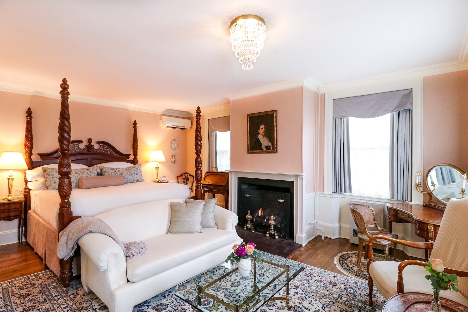 A room with a queen bed, fireplace, and seating area, at one of the best hotels in Exeter New Hampshire.