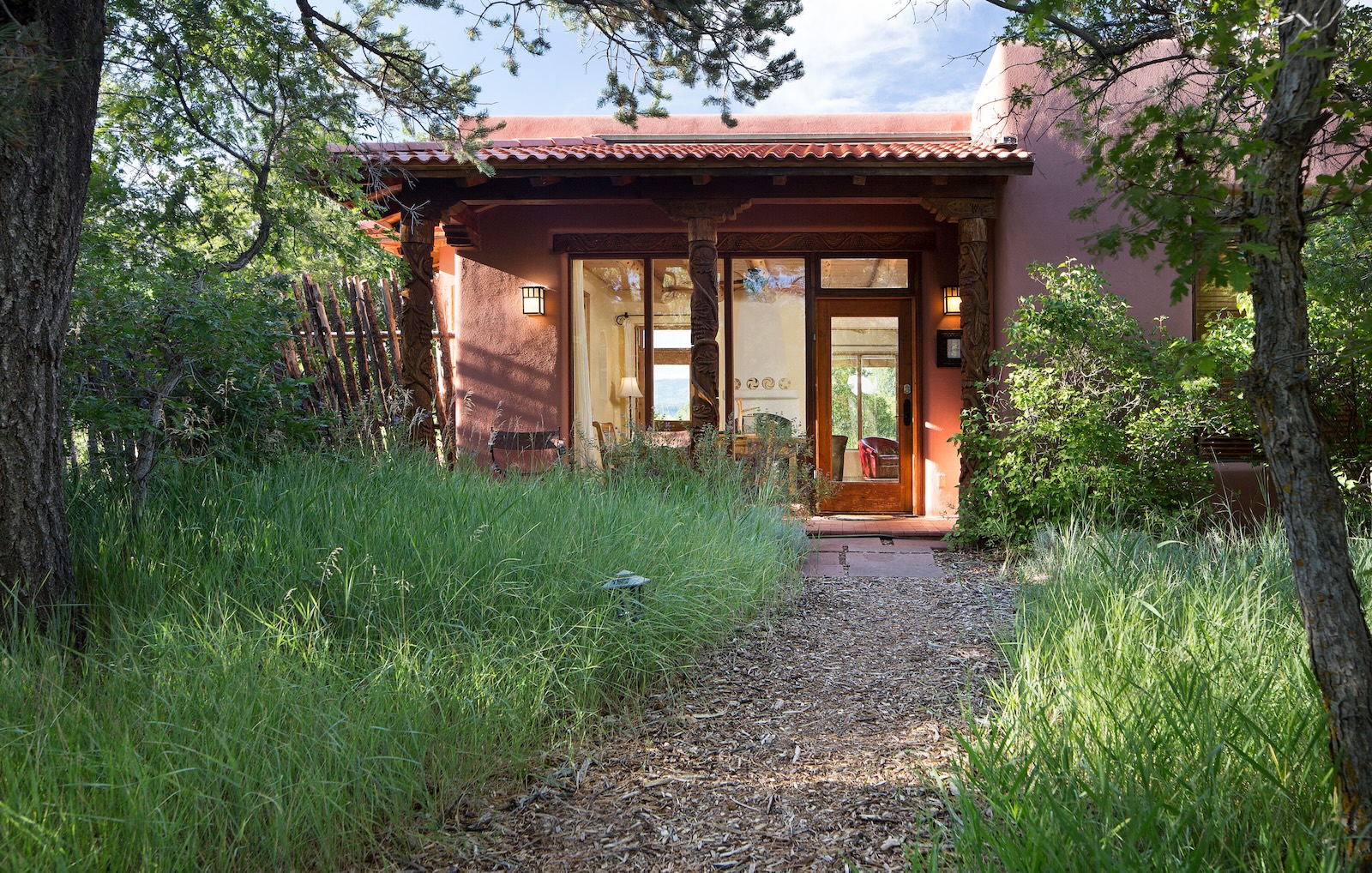 A cozy building framed by trees with a path leading to the front door, what you can expect to find at the best Durango lodging.