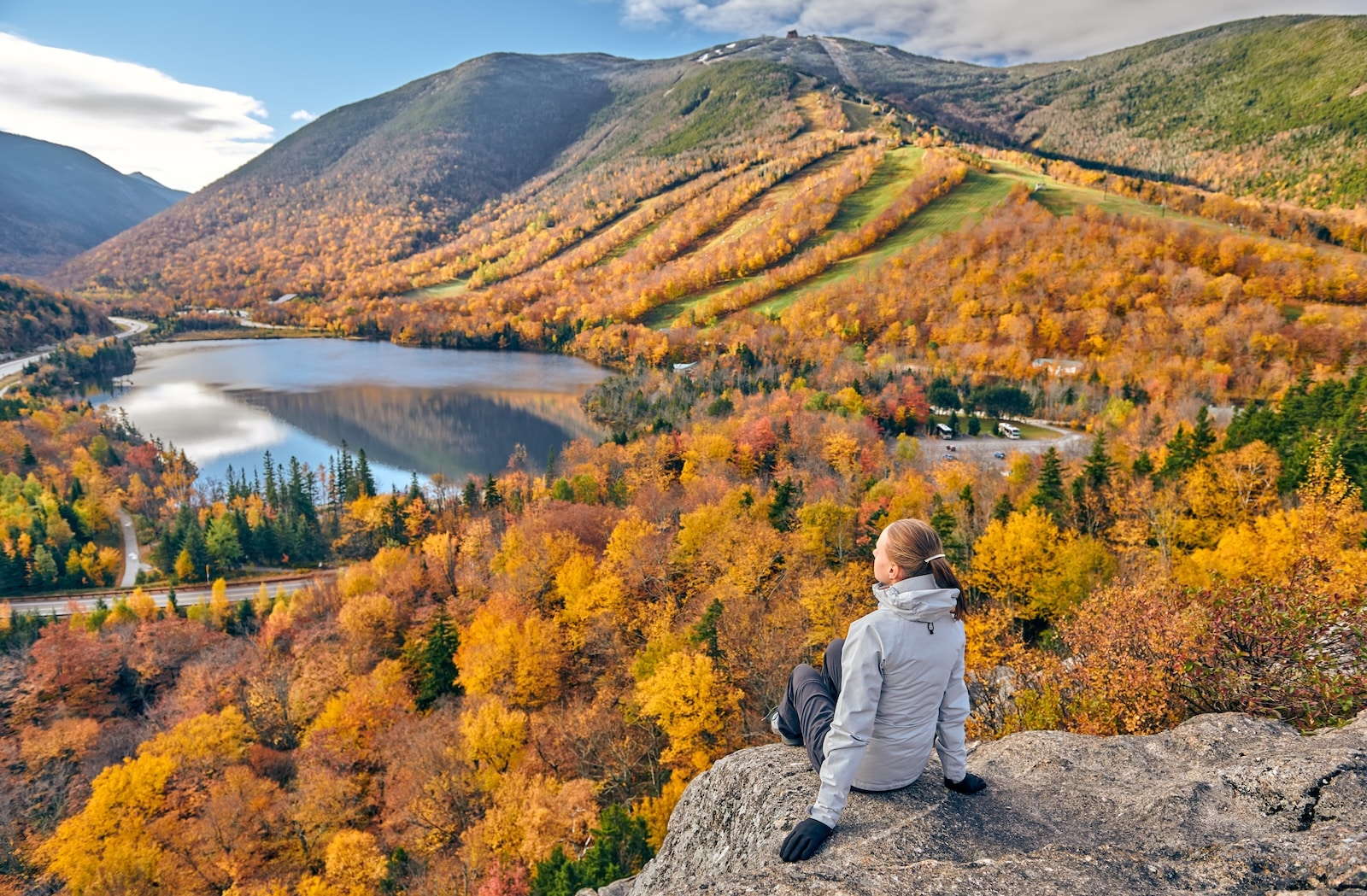 Woman hiking at Artist's Bluff in autumn in Franconia Notch State Park.