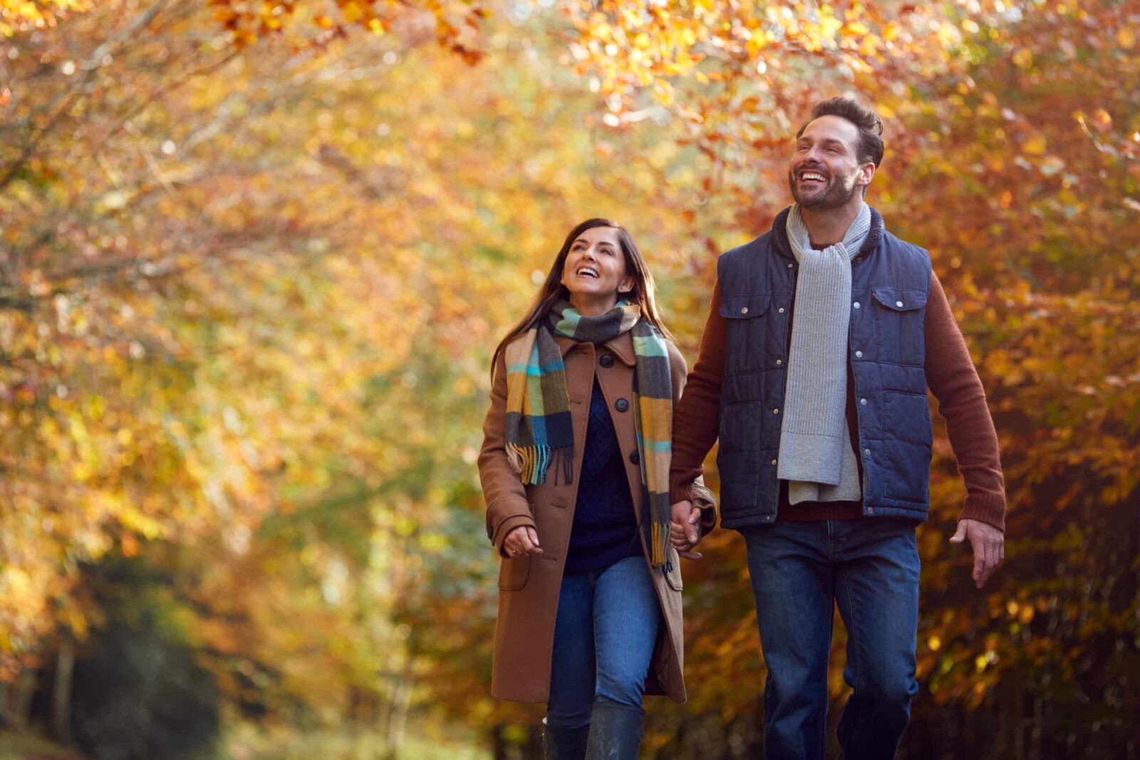 Couple walking together among fall foliage